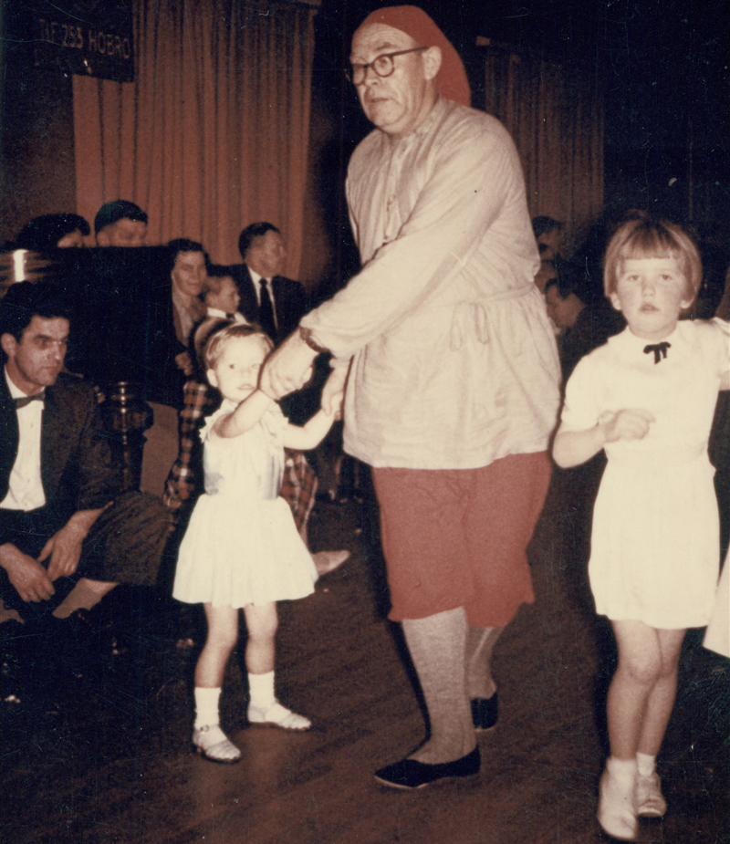 Julenissen danser med børnene.